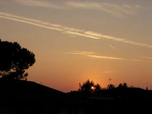 tramonto in particolare tramonto con scie di aereo che formano graffi al quadro, tramonto immagini, foto tramonto, foto al tramonto